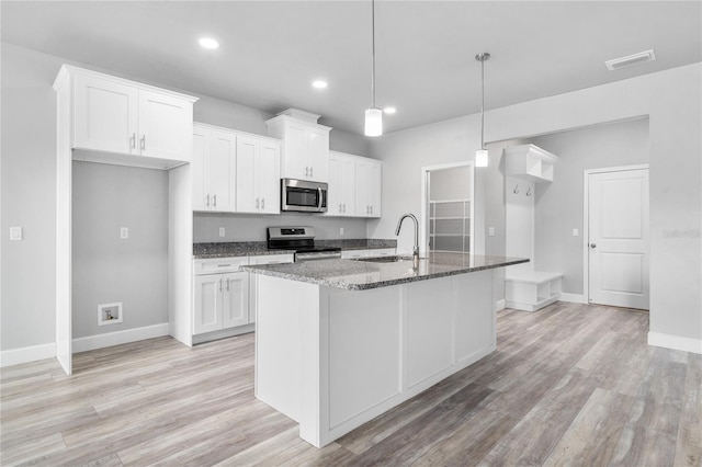 kitchen with white cabinetry, an island with sink, appliances with stainless steel finishes, and sink