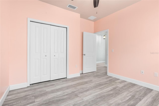 unfurnished bedroom featuring ceiling fan, light wood-type flooring, and a closet