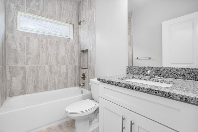 full bathroom featuring vanity, tiled shower / bath combo, and toilet