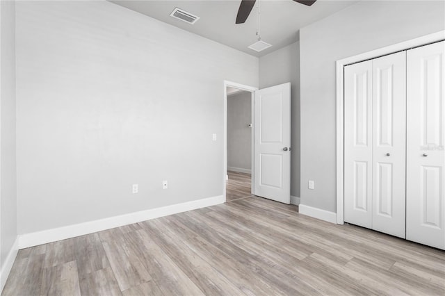 unfurnished bedroom with ceiling fan, light wood-type flooring, and a closet