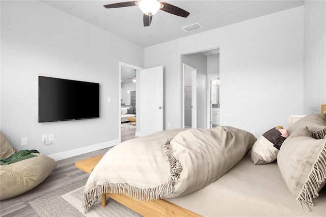 bedroom with connected bathroom, hardwood / wood-style floors, and ceiling fan