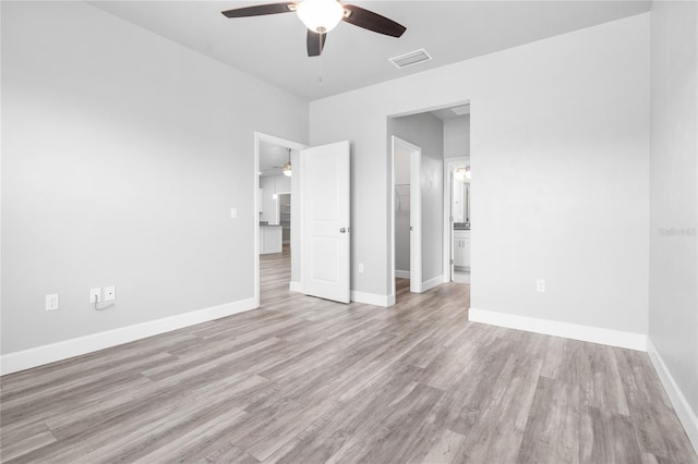 unfurnished bedroom featuring connected bathroom, light hardwood / wood-style floors, and ceiling fan