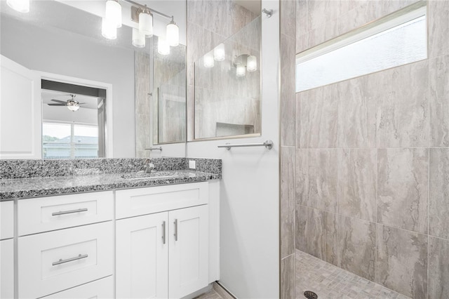 bathroom with vanity, ceiling fan, and tiled shower