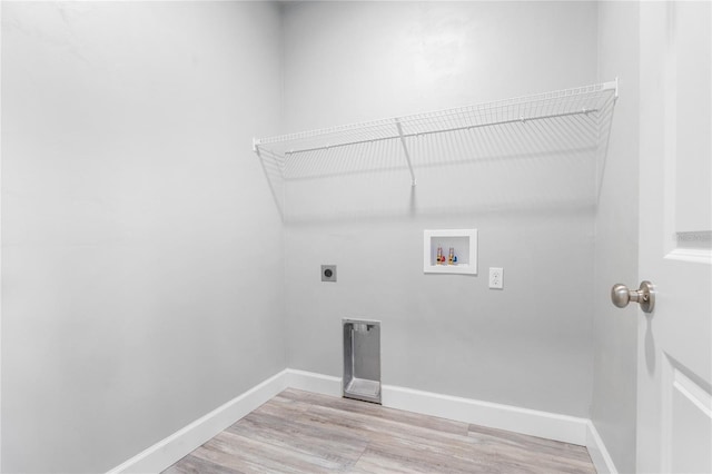 clothes washing area with electric dryer hookup, hookup for a washing machine, and light wood-type flooring