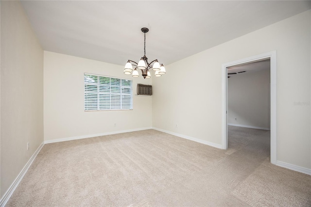 unfurnished room with baseboards, an inviting chandelier, and light colored carpet