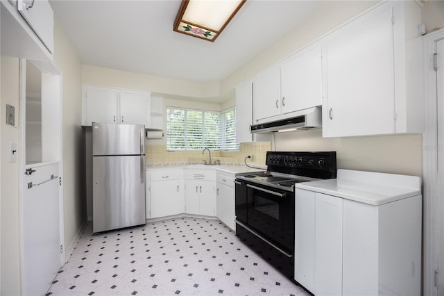 kitchen featuring light floors, black range with electric stovetop, freestanding refrigerator, under cabinet range hood, and a sink