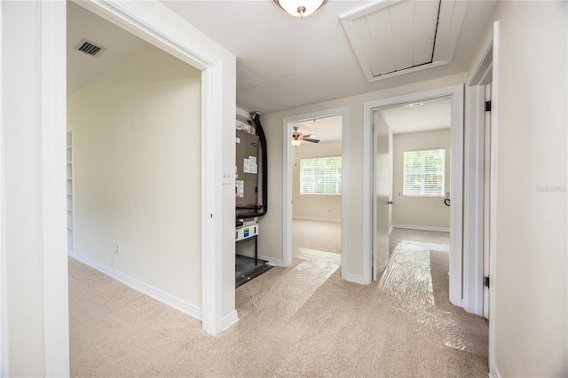 corridor featuring visible vents, carpet floors, attic access, and baseboards