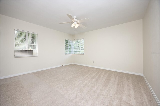 unfurnished room featuring a wealth of natural light, carpet flooring, and ceiling fan