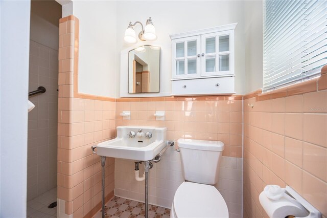 bathroom featuring a tile shower, backsplash, toilet, tile patterned flooring, and tile walls