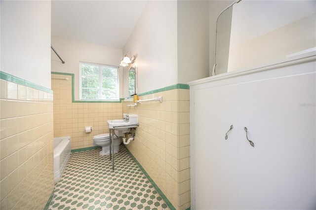 full bathroom featuring shower / bath combination, toilet, tile patterned floors, tile walls, and sink