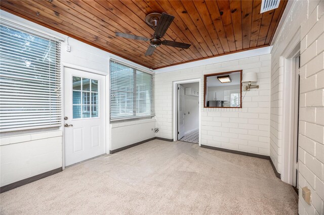 unfurnished sunroom featuring wooden ceiling and ceiling fan