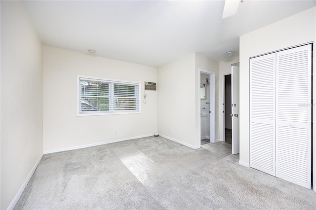 unfurnished bedroom featuring ceiling fan, connected bathroom, a closet, and light carpet