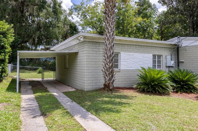 view of home's exterior featuring a carport and a lawn