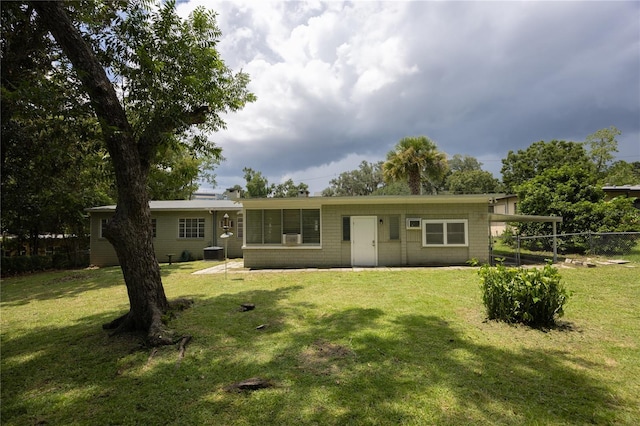 rear view of house featuring a lawn, fence, and central air condition unit