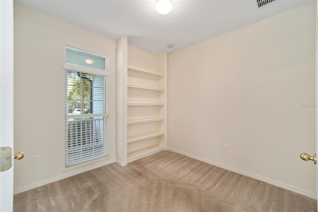 spare room featuring light colored carpet