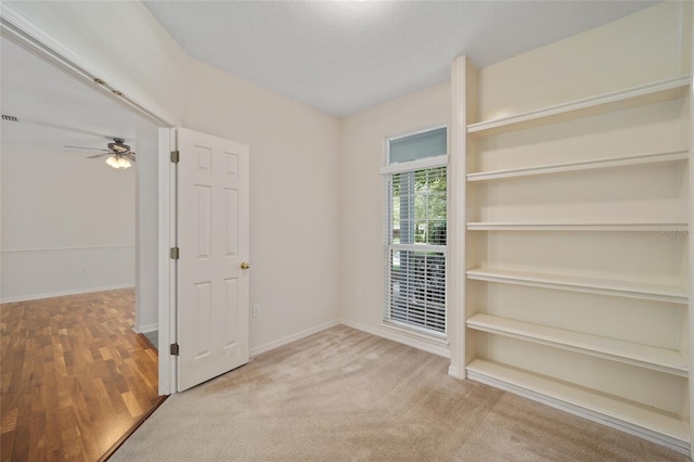 interior space featuring ceiling fan and light carpet