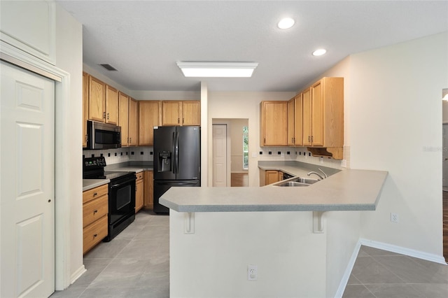 kitchen with light tile patterned flooring, sink, decorative backsplash, and black appliances