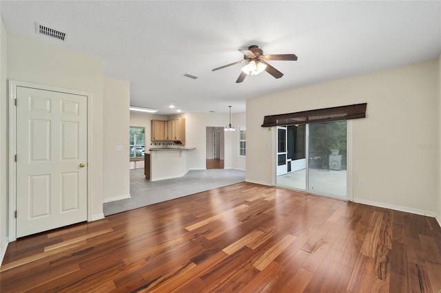 unfurnished living room featuring ceiling fan and hardwood / wood-style floors