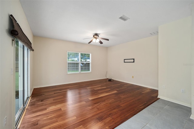 empty room with ceiling fan and tile patterned floors