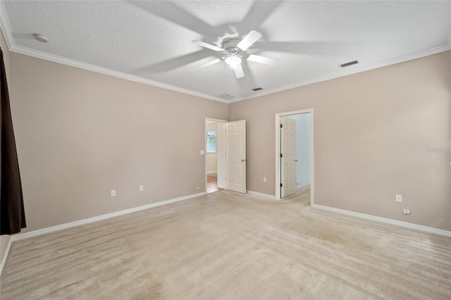 carpeted spare room with ceiling fan, a textured ceiling, and crown molding