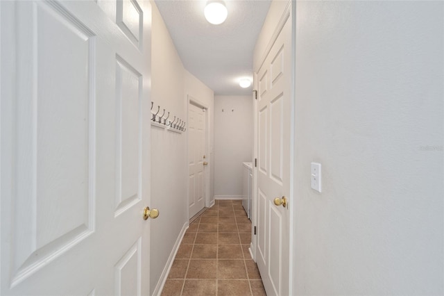 hallway featuring tile patterned floors and a textured ceiling