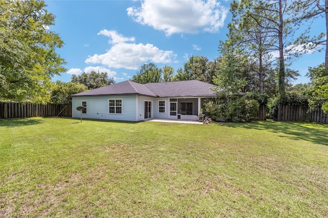 back of house featuring a patio area and a lawn