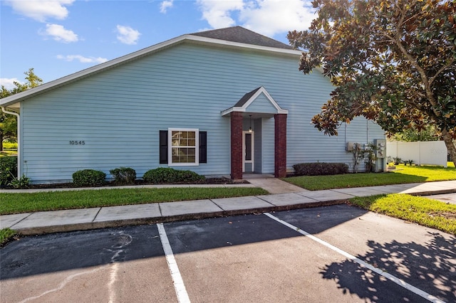 10545 NW 30th Ln, Gainesville, FL 32606 - view of front facade with a front lawn, uncovered parking, and fence