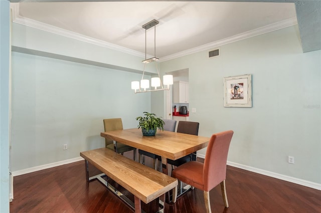 dining area featuring dark hardwood / wood-style flooring, a notable chandelier, and crown molding