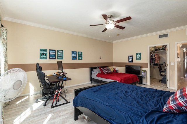 bedroom featuring ceiling fan, a spacious closet, light hardwood / wood-style flooring, and crown molding