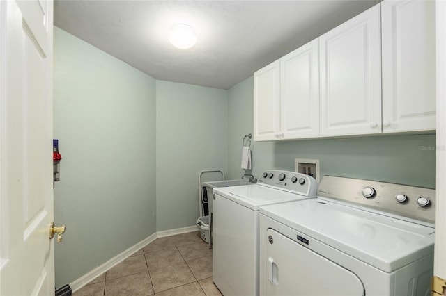 laundry room featuring washer and clothes dryer, cabinets, and light tile patterned floors