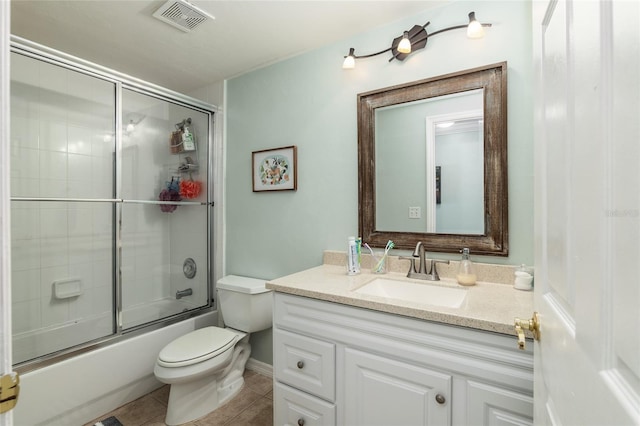 full bathroom featuring combined bath / shower with glass door, toilet, vanity, and tile patterned floors