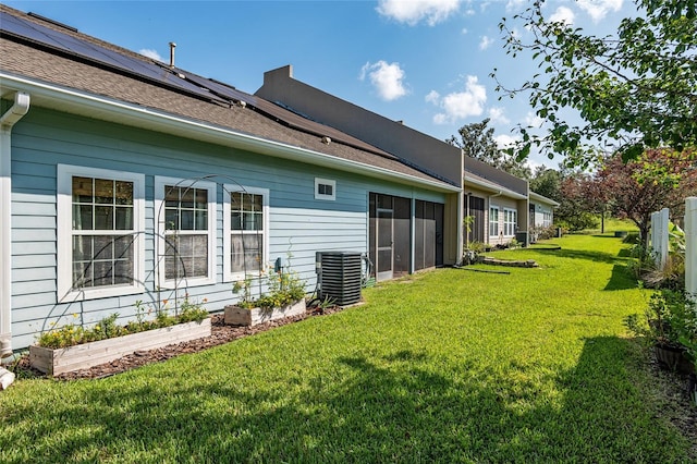 10545 NW 30th Ln, Gainesville, FL 32606 - rear view of property with roof mounted solar panels, roof with shingles, a yard, and central air condition unit