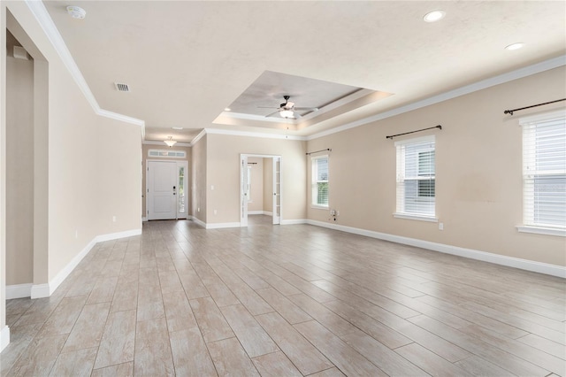 spare room featuring crown molding, a tray ceiling, ceiling fan, and light hardwood / wood-style flooring