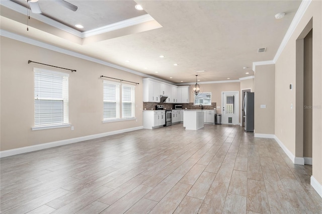 unfurnished living room with ornamental molding, sink, ceiling fan with notable chandelier, and light hardwood / wood-style flooring