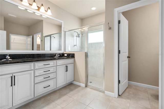 bathroom featuring vanity, a shower with shower door, and tile patterned flooring