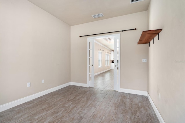 empty room with light hardwood / wood-style floors and a barn door