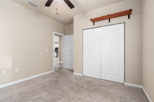 unfurnished bedroom featuring light carpet, ceiling fan, and a closet