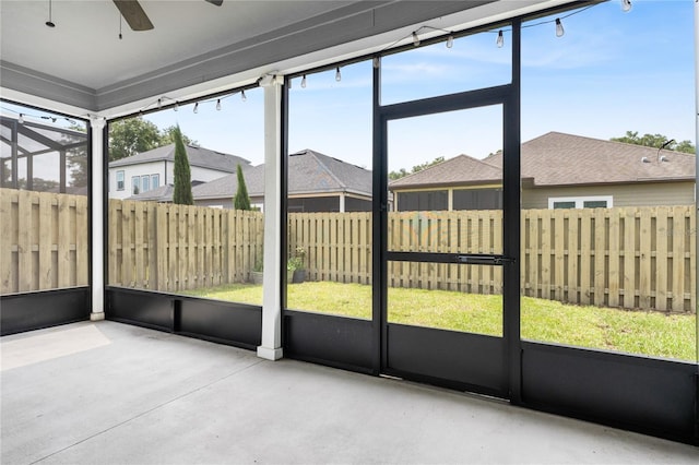 unfurnished sunroom featuring ceiling fan