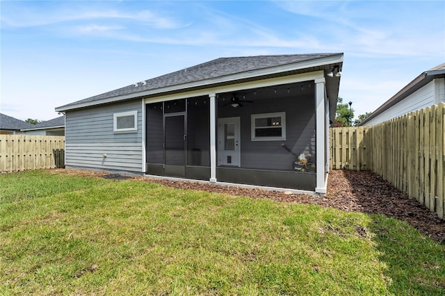 rear view of house featuring a yard and a sunroom