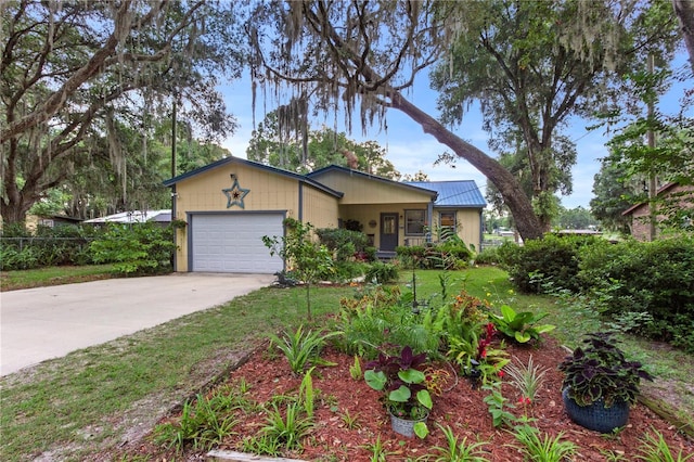 view of front of property with a garage, metal roof, a front lawn, and concrete driveway