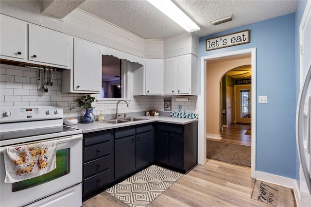 kitchen with sink, white cabinets, light hardwood / wood-style flooring, and white electric range