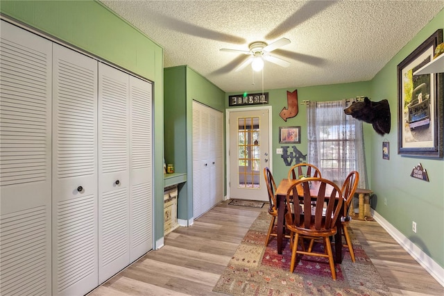 dining room featuring a textured ceiling, light hardwood / wood-style flooring, and ceiling fan