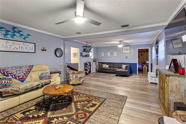 living room with ornamental molding, wood finished floors, and visible vents