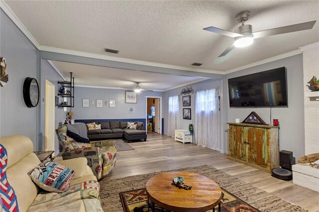 living room with ceiling fan, crown molding, and light hardwood / wood-style floors