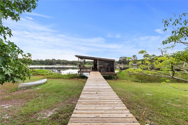 dock area featuring a lawn and a water view