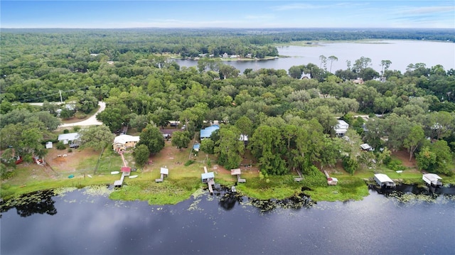 aerial view featuring a forest view and a water view