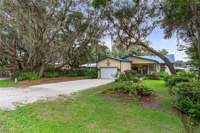 single story home featuring a garage and a front lawn