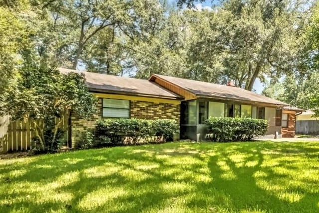 single story home featuring a front lawn