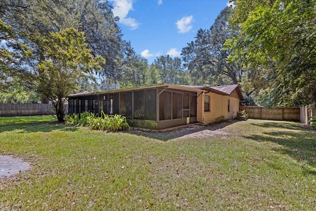 view of home's exterior featuring a sunroom and a yard