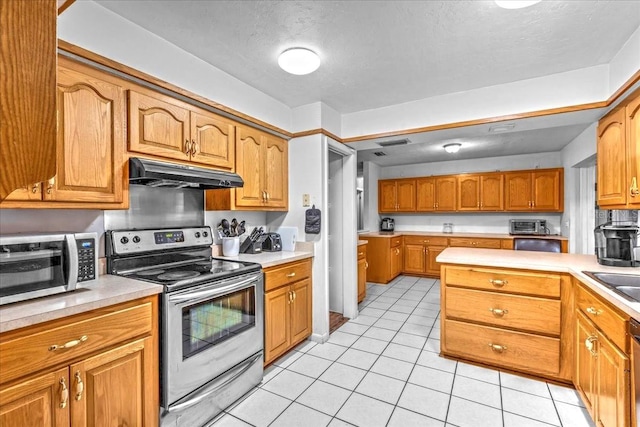 kitchen with light tile patterned flooring, appliances with stainless steel finishes, and sink